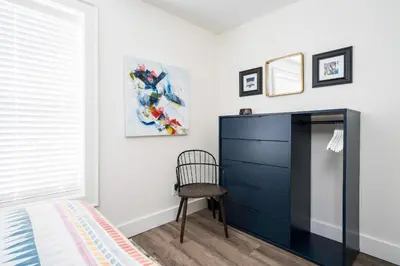a bedroom with a blue dresser and a chair at 
