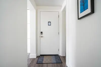 a hallway with a white door and a rug at 