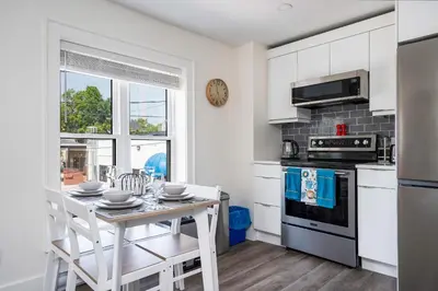 a white kitchen with a table and a stove at 