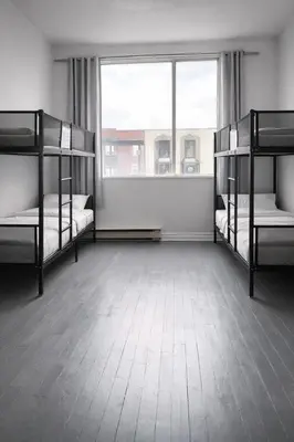 a room with three bunk beds and a window at Zen Hostel in Toronto