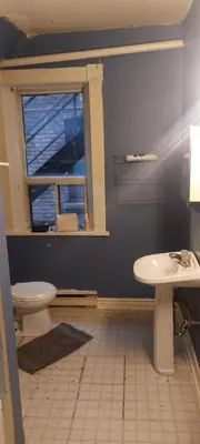 a bathroom with a toilet and a sink and a window at Zen Hostel in Toronto