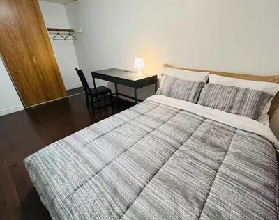 a bedroom with a bed and a table with a lamp at ComfyRoom in Toronto