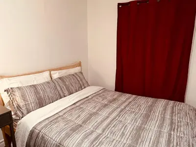 a bedroom with a bed and a red curtain at ComfyRoom in Toronto