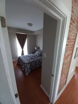a bedroom with a bed and a brick wall at Niagara Falls Dream Family Retreat in Niagara Falls
