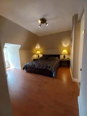 a bedroom with a bed and a wooden floor at Niagara Falls Dream Family Retreat in Niagara Falls
