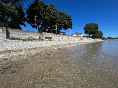 a beach with a retaining wall and the water at Beach House in Niagara in Wainfleet