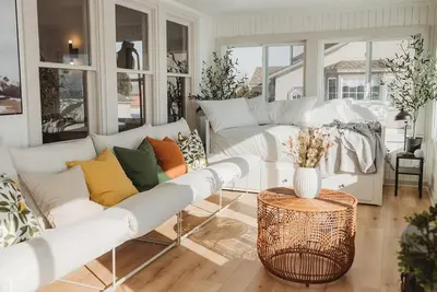 a living room with white couches and a table at Beach House in Niagara in Wainfleet