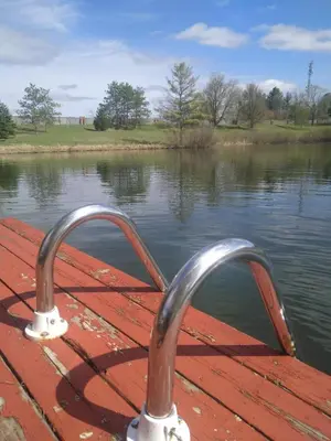 a boat with a metal railing on a body of water at Lakeside Private suite-Queen bed room in Tottenham