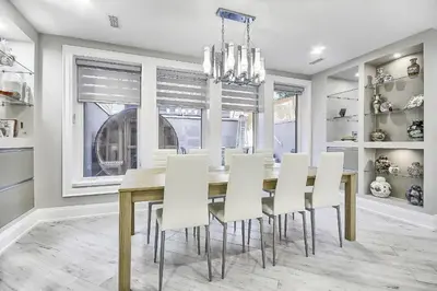 a dining room with a table and white chairs at Charming and Luxurious 2BR+1Bath Guest Suite in Toronto
