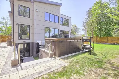 a large white house with a fence in the yard at Charming and Luxurious 2BR+1Bath Guest Suite in Toronto