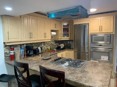 a kitchen with stainless steel appliances and wooden cabinets at Guest House Room No 01 in Mississauga