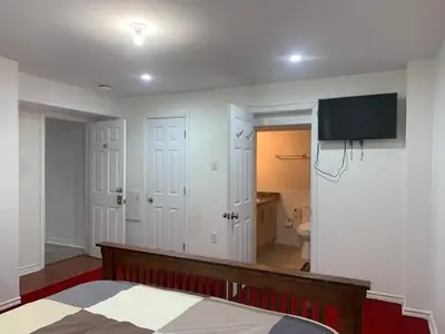 a bedroom with a bed and a flat screen tv at Guest House Room No 01 in Mississauga
