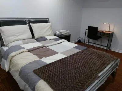 a large bed in a room with a chair at Guest House Room No 02 in Mississauga