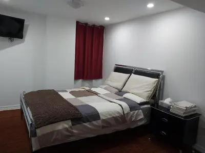 a bedroom with a bed and a red curtain at Guest House Room No 02 in Mississauga
