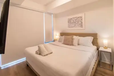 a bedroom with a large white bed with a window at PET FRIENDLY CONDOS at FRIDAY HARBOUR in Innisfil