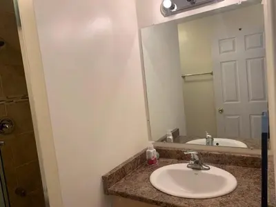 a bathroom with a sink and a large mirror at Guest House Room No 03 in Mississauga