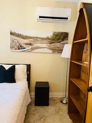a bedroom with a bed and a painting on the wall at SouthLake Cottage on The Lake. in Washago