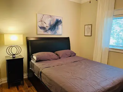 a bedroom with a bed and a lamp and a window at SouthLake Cottage on The Lake. in Washago