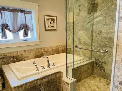 a bathroom with a tub and a glass shower at SouthLake Cottage on The Lake. in Washago