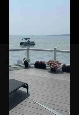 a boat in the water with a bench on a pier at SouthLake Cottage on The Lake. in Washago