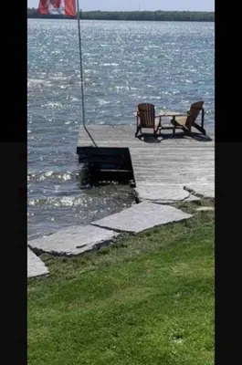 two benches sitting on a dock next to the water at SouthLake Cottage on The Lake. in Washago