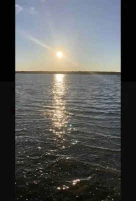 a sun setting over a large body of water at SouthLake Cottage on The Lake. in Washago