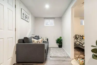 a living room with a gray couch in a room at Cozy nest basement unit in Hamilton