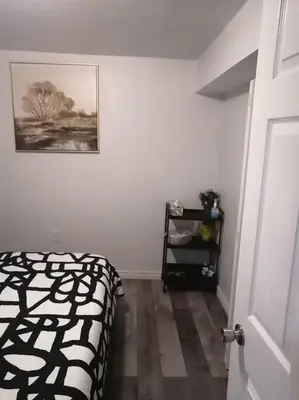 a bedroom with a bed and a picture on the wall at Cozy nest basement unit in Hamilton