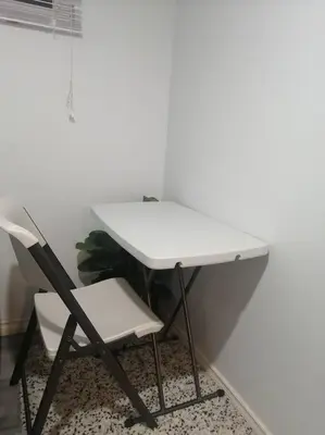 a white desk and a chair next to a wall at Cozy nest basement unit in Hamilton