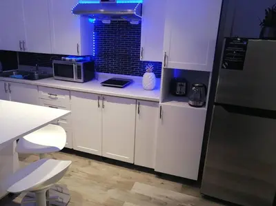 a kitchen with white cabinets and a counter top at Cozy nest basement unit in Hamilton