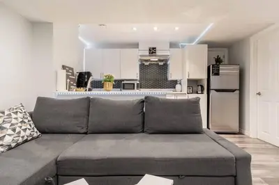 a living room with a couch and a kitchen at Cozy nest basement unit in Hamilton