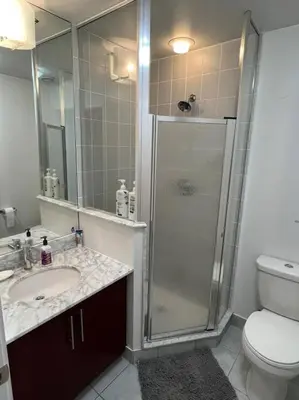 a bathroom with a shower and a sink and a toilet at Prestigious 2-Bdrm Condo - across from Scotiabank Arena in Toronto