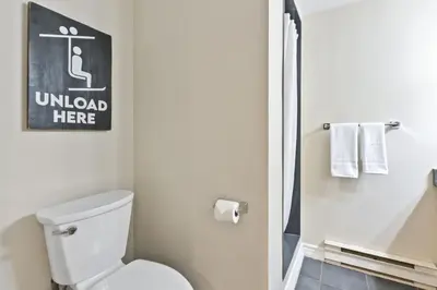 a bathroom with a toilet and a sign on the wall at Blue Mountain Chalet Condo with Amazing Location in Blue Mountains