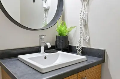 a bathroom with a white sink and a mirror at Blue Mountain Chalet Condo with Amazing Location in Blue Mountains