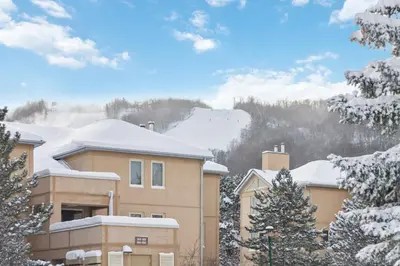 a house in the snow with snow covered trees at Blue Mountain Chalet Condo with Amazing Location in Blue Mountains