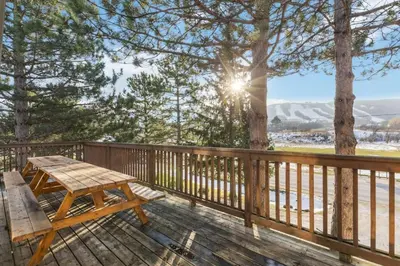 a wooden deck with a wooden picnic table on it at Large Chalet for up to 16 ppl close to mountains in Blue Mountains