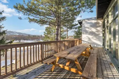 a wooden bench sitting on the porch of a house at Large Chalet for up to 16 ppl close to mountains in Blue Mountains