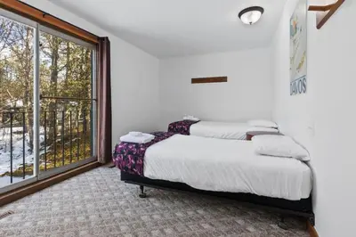 a bedroom with two beds and a large window at Large Chalet for up to 16 ppl close to mountains in Blue Mountains