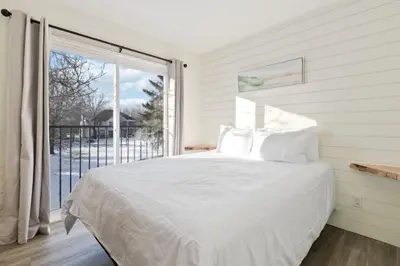 a bedroom with a bed and a large window at Four Peaks - Unit 40B in Collingwood