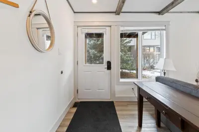 a living room with a bench and a mirror at Four Peaks - Unit 40B in Collingwood