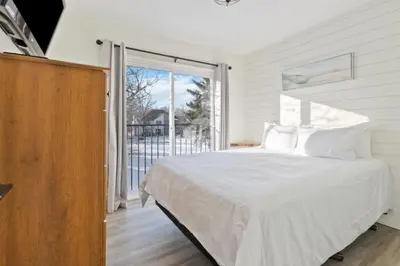 a bedroom with a white bed and a large window at Four Peaks - Unit 40B in Collingwood