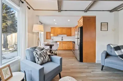 a living room with two chairs and a kitchen at Four Peaks - Unit 40B in Collingwood