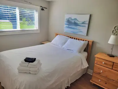 a bedroom with a white bed with towels on it at Panoramic-Blue Mountain-Balcony-Sauna-Backyard-King in Blue Mountains