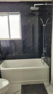 a bathroom with a white tub and a toilet at Mama Gol in Richmond Hill