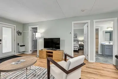 a living room with a table and a television at The Nordic - Central Collingwood Condo in Collingwood