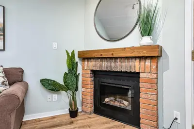 a living room with a fireplace and a mirror at The Nordic - Central Collingwood Condo in Collingwood
