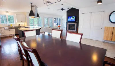 a kitchen and living room with a wooden table and chairs at Mountain House in the Heart of Haliburton, Mins to Lake in Haliburton