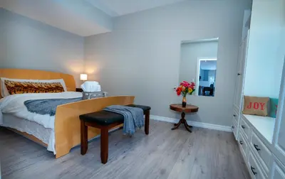 a bedroom with a bed and a table and a chair at Mountain House in the Heart of Haliburton, Mins to Lake in Haliburton