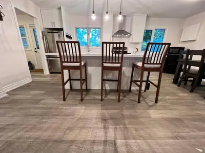 a kitchen with three chairs and a table in a room at Marmora Hideaway - Lake front in Marmora