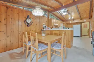 a wooden kitchen with a wooden table and chairs at Rustic cottage on Canal Lake in Carden